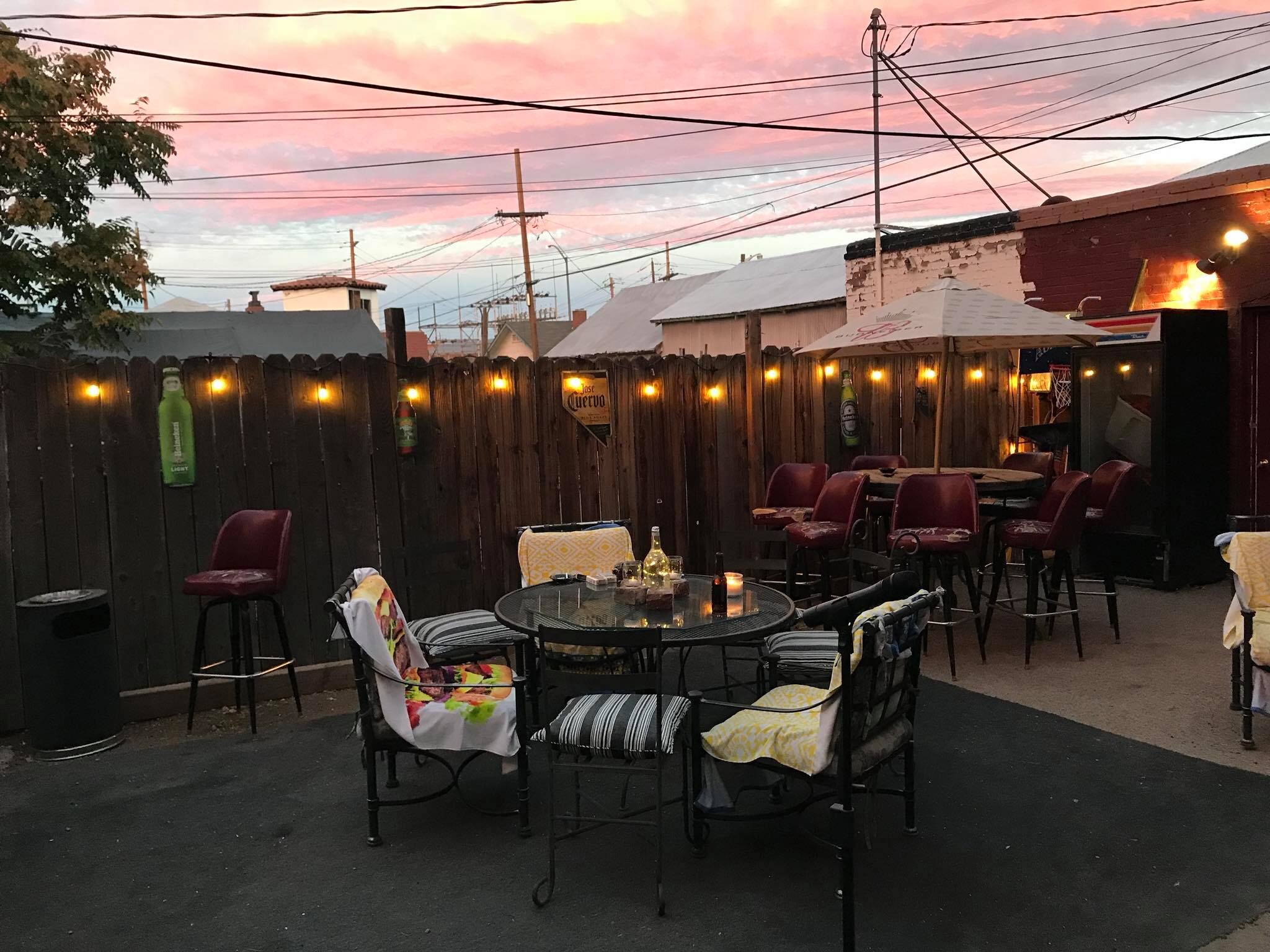 The outdoor patio at 4th Street Bar under a pink evening sky