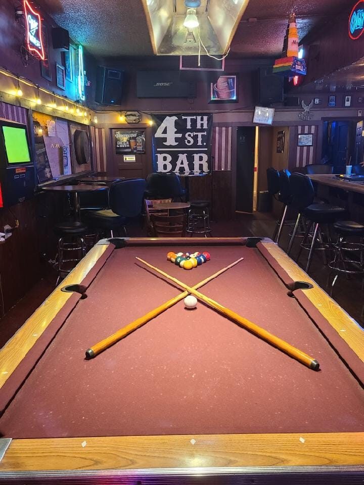 Pool table and crossed cues inside 4th Street Bar